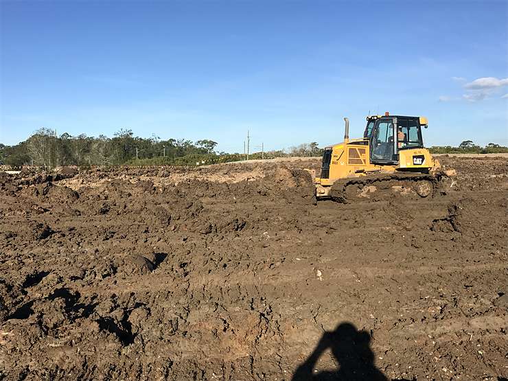 Dozer pushing wet clay